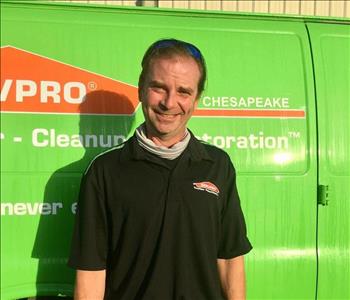 Male employee in front of green SERVPRO van 